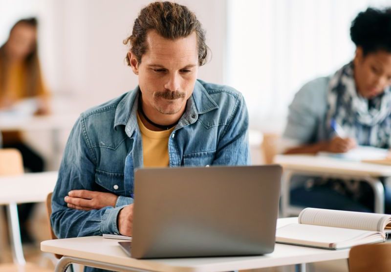 Student using laptop in classroom